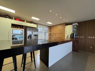 Foto de uma cozinha moderna com armários brancos e ilha escura.