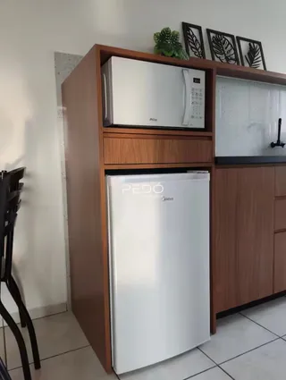 Armário de cozinha com geladeira branca e bancada de madeira.