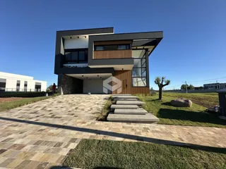 Fachada moderna de uma residência em Lajeado, Brasil, com área externa pavimentada.