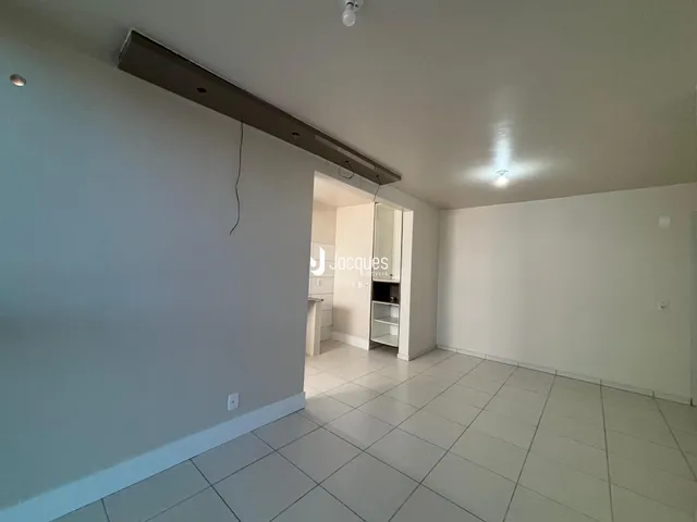 Interior de uma sala com piso de cerâmica e paredes brancas.