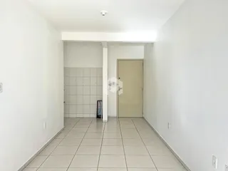 Corredor interno de uma residência com paredes brancas e piso de cerâmica.