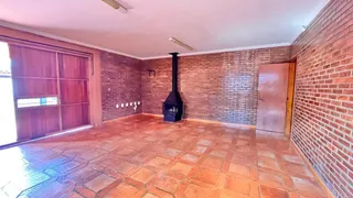 Sala de estar com piso de terracota e paredes de tijolo aparente.