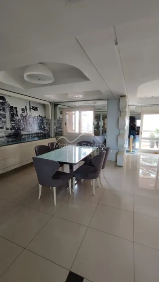Esta é uma sala de jantar com mesa de vidro e cadeiras modernas.
