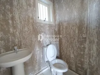 Foto de um banheiro interno com vaso sanitário branco e parede texturizada.