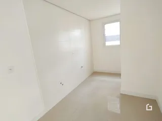 Vista interna de um ambiente com paredes brancas e piso claro.