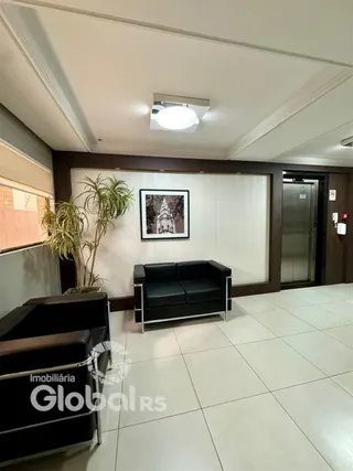 Sala de estar com sofá escuro e moldura de madeira.