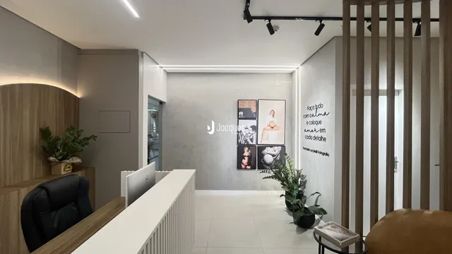 Interior de uma sala de estar moderna com piso claro e paredes brancas.