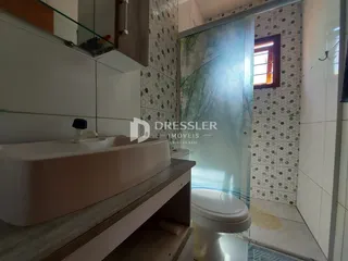 Banheiro com revestimento de cerâmica e porta de vidro.