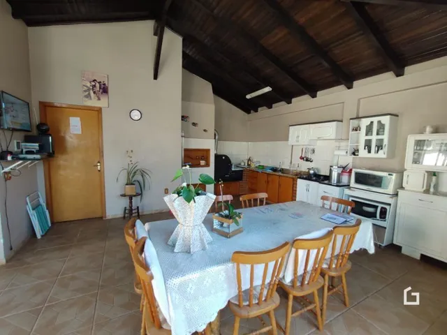 Mesa de jantar com cadeiras em uma sala com teto de madeira.