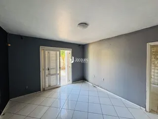 Interior de um ambiente com piso de cerâmica e paredes cinzas.