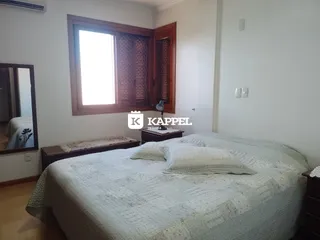 Quarto com cama grande e janela de madeira.