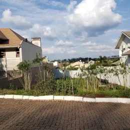 Vista externa da propriedade mostrando o muro e o paisagismo.
