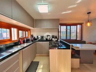 Vista da cozinha moderna com armários e bancadas escuras.