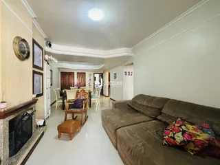 Sala de estar com lareira e móveis de madeira em imóvel no Brasil.