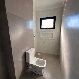 Foto de um banheiro mostrando um vaso sanitário branco.