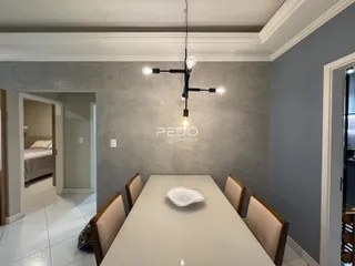 Sala de jantar com mesa e cadeiras em um ambiente claro.