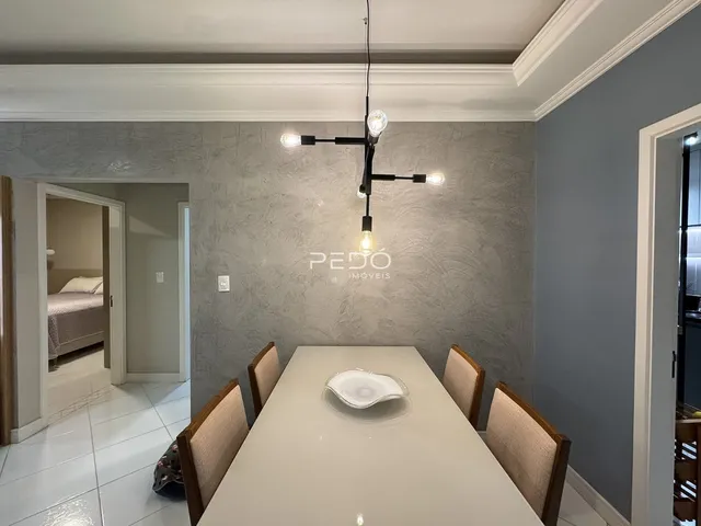 Sala de jantar com mesa e cadeiras em um ambiente claro.