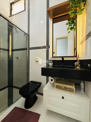 Foto de um banheiro com revestimento de azulejos brancos e pretos.