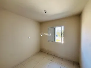 Quarto interno com piso de cerâmica e janela com venezianas brancas.
