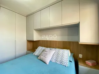 Quarto com cabeceira e armários brancos.