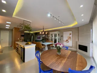 Interior de uma sala de jantar e cozinha moderna com mesa de madeira.