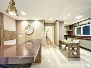 Interior de uma sala de jantar moderna com mesa de madeira e decoração em Lajeado.