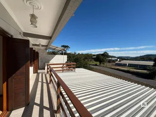 Vista da varanda com piso de telha metálica e paisagem ao fundo.