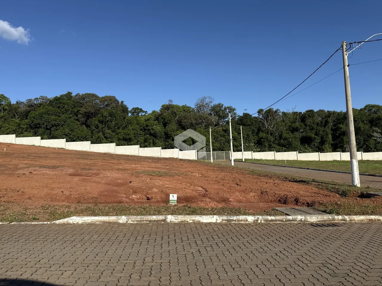 Vista da divisa de uma propriedade com cerca e vegetação.