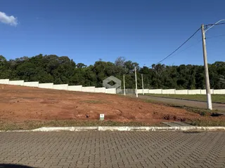 Vista da divisa de uma propriedade com cerca e vegetação.
