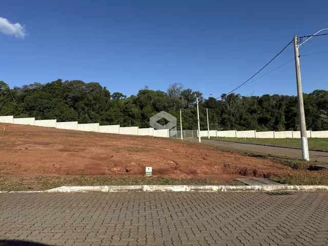 Vista da divisa de uma propriedade com cerca e vegetação.