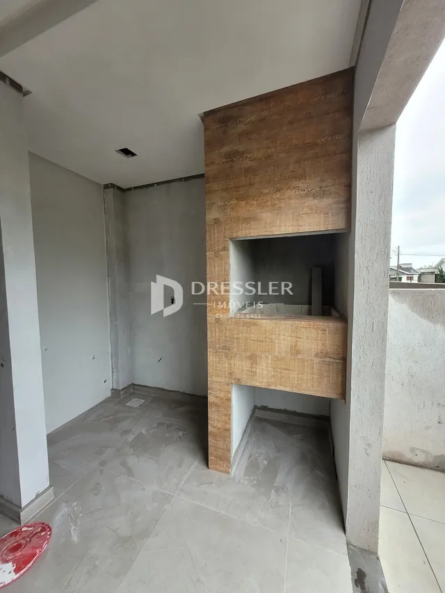 Foto de um interior com paredes brancas e piso de concreto exposto.