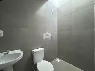 Foto de um banheiro com revestimento cinza nas paredes.