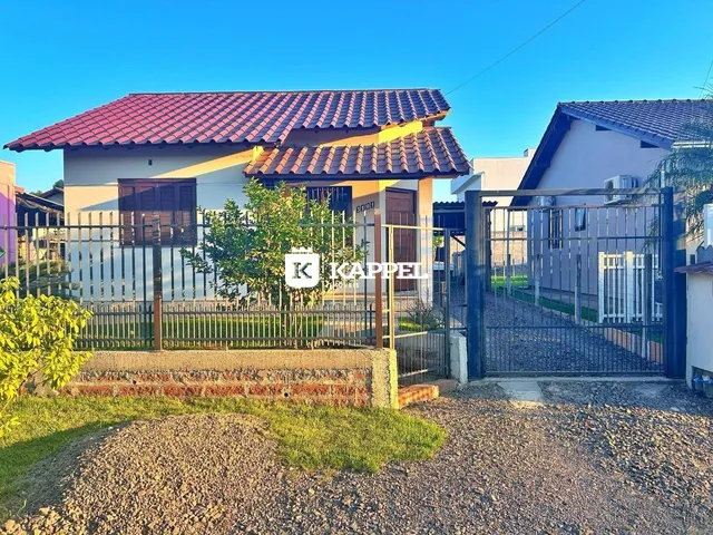 Foto da fachada de uma casa residencial em Lajeado, Brasil, com cerca e portão de segurança.