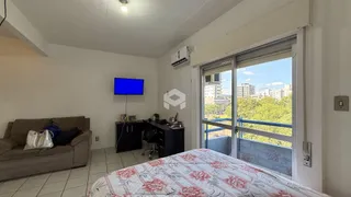 Sala de estar com sofá e televisão em um apartamento no Brasil.
