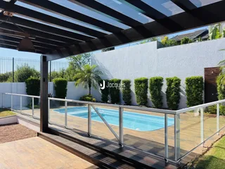 Vista da piscina e área externa com muro e vegetação em Lajeado.