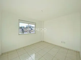 Interior de um cômodo com piso de cerâmica e janela.