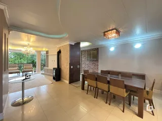 Sala de estar com mesa de jantar e iluminação clara em um ambiente amplo.