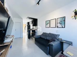 Sala de estar moderna com sofá cinza e piso de cerâmica.
