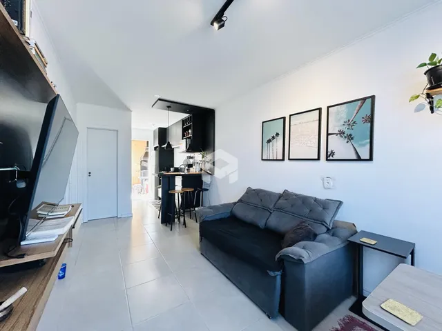 Sala de estar moderna com sofá cinza e piso de cerâmica.