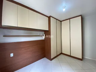 Interior de uma sala com armários planejados de madeira e piso cerâmico.