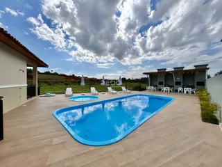 Foto de uma piscina externa com espreguiçadeiras em um quintal.