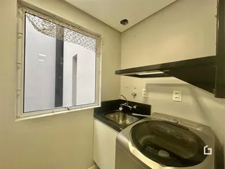 Foto de uma área de serviço com máquina de lavar e janela em um imóvel.