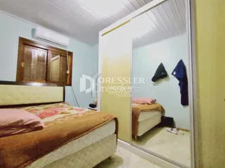 Quarto com cama e armário de madeira em um imóvel.