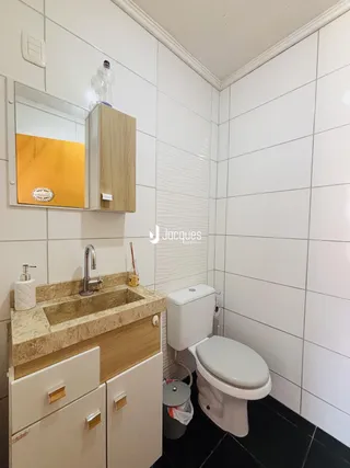 Foto de um banheiro com revestimento de azulejos brancos e bancada de granito.