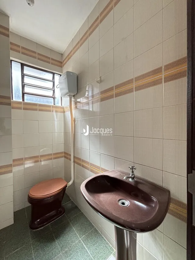 Banheiro com revestimento de azulejos nas paredes e piso.