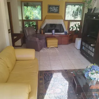 Sala de estar com sofá amarelo e lareira em ambiente residencial.
