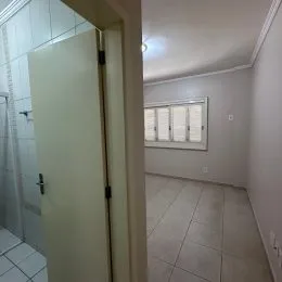 Hall de entrada com piso de cerâmica e paredes brancas.
