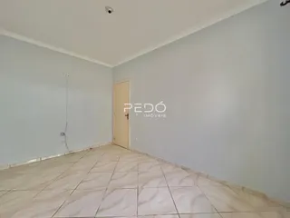 Ambiente interno de uma sala com piso de cerâmica e paredes brancas.