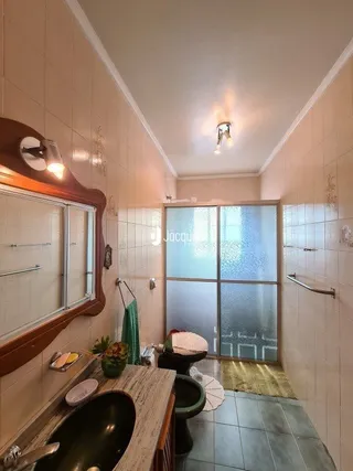Interior de um corredor com revestimento de madeira e piso cerâmico.