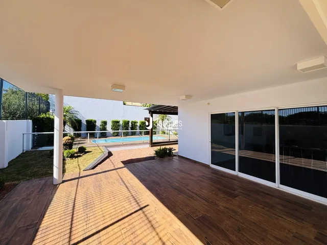 Espaço aberto com deck de madeira e vista para a piscina no quintal.